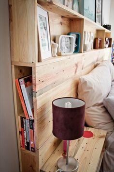 there is a lamp that is next to the bookshelf on the bed in this room