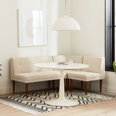 a living room with white furniture and a round table