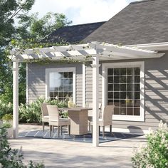 a patio with chairs, table and potted plants on the side of the house