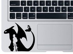a laptop computer with a sticker of a dragon next to it's keyboard