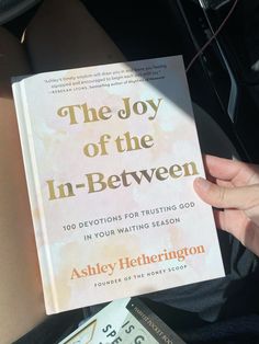 the joy of the in - between book being held by someone