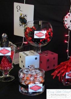 a table topped with lots of candy and candies next to diced up cards