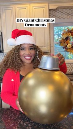 a woman in a santa hat holding a christmas ornament with the words diy giant christmas ornaments on it