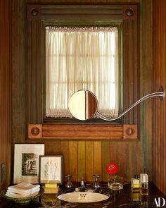 a bathroom with a sink, mirror and pictures on the counter in front of it