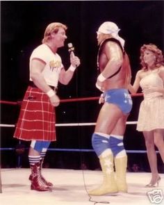 two women and one man are talking to each other in a wrestling ring with the referee