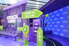 an exhibit with purple walls and green signs