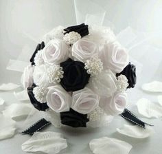a bridal bouquet with black and white flowers on the bottom is surrounded by petals