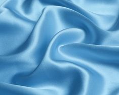 a close up view of a light blue satin fabric