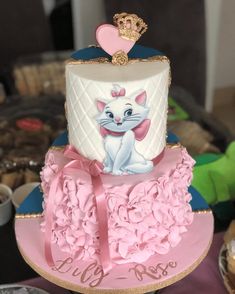 there is a cake with a cat on it that has pink flowers around the edges