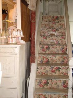 a set of stairs leading up to a room with flowers on the carpet and walls