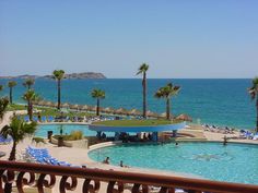 an outdoor swimming pool next to the ocean