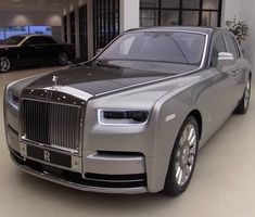 a silver rolls royce parked in a showroom