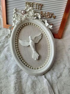 a white frame with a bird and flowers on it next to a sign that says pretty baby