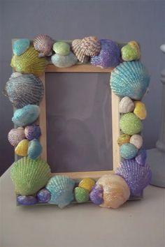 a photo frame made out of seashells on a table