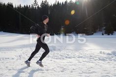 a man running in the snow on a sunny day