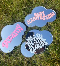 three mirrors that have been placed in the grass with some writing on one of them