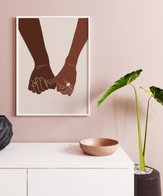 two hands holding each other's hand in front of a pink wall with a plant