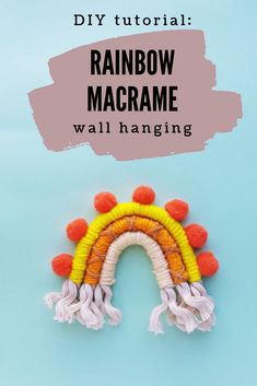 the rainbow macrame wall hanging is made with yarn and pom poms