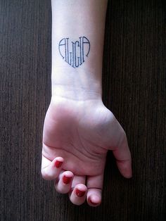 a person's arm with a small tattoo on the wrist and name written on it