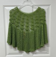 a crocheted top hanging on a door