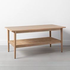 a wooden coffee table sitting on top of a hard wood floor next to a white wall