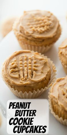 several cupcakes with peanut butter frosting sitting on a white platter next to each other