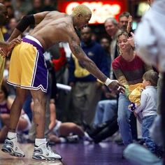 a man with no shirt on standing in front of a crowd holding a basketball ball