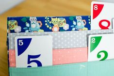 a close up of a wallet with numbers and cards in it on a wooden table