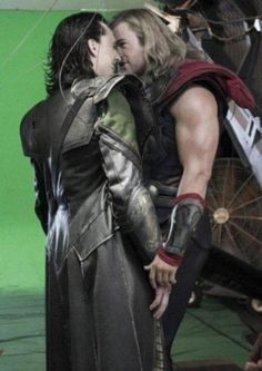 two people dressed as thor and loki in front of a green screen