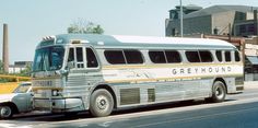 an old greyhound bus is parked on the side of the road