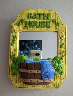 a bathroom mirror that has a basket on it and the words bath house above it