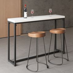 two stools sit under a table with wine glasses on it