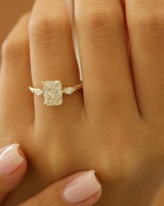 a woman's hand with a ring on it and a diamond in the middle