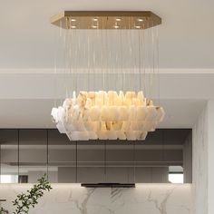 a modern chandelier hanging from the ceiling in a room with marble walls and flooring