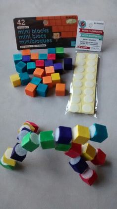 several different colored blocks next to each other on a white surface with a pack of them