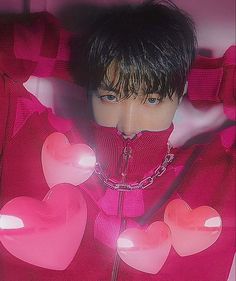 a man with black hair wearing a pink sweater and heart shaped decorations on his face