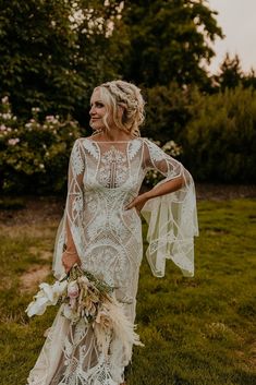 a woman in a wedding dress standing on the grass