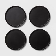 four black plates sitting on top of each other