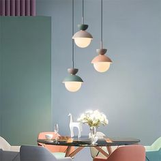 a dining room table with chairs and lights hanging from it's ceiling over it