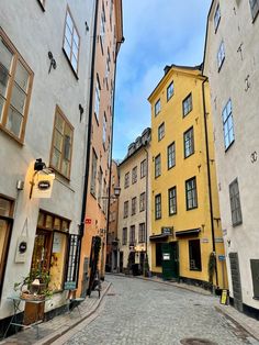 an empty street with several buildings on both sides and one building in the middle that is yellow