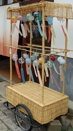 a small cart that is sitting on the sidewalk with some items hanging off it's sides