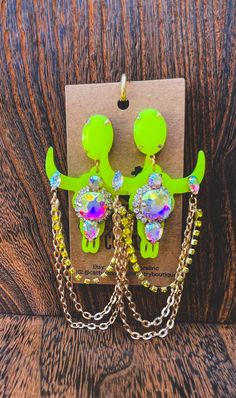 Add a pop of color to your outfit with these Neon Yellow longhorn steer earrings. Adorned with rhinestone chain and big rhinestone jewels. Perfect for those with a cowgirl spirit, these longhorn earrings are a must-have for your western jewelry collection! Whether you're dressing up for a rodeo or just want to show off your unique style, these earrings are sure to make a statement. A great gift for your girlfriend too! #LonghornEarrings #CowgirlSpirit #SouthwesternJewelry #RodeoFashion Punchy Cowgirl, Outfit Western, Longhorn Steer, Cowgirl Outfit