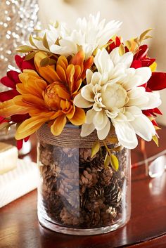 a vase filled with lots of flowers on top of a table