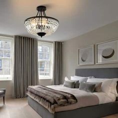 a bedroom with a large bed and chandelier