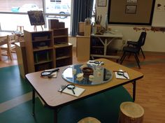 a table with several items on it in a room filled with books and other things