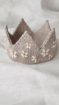 a knitted crown sitting on top of a bed