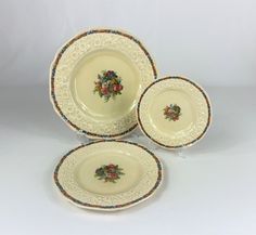 three plates with floral designs on them sitting next to each other