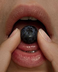 a person holding a blueberry up to their mouth with the word'i love you'written on it