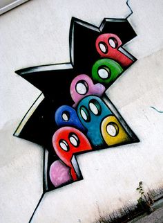 graffiti on the side of a building that has been painted with different colors and shapes