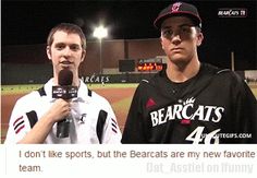 two baseball players standing next to each other on a field at night, one is holding a microphone